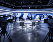 Studio de télévision abstrait, silhouettes floues autour d’une table de débat, éclairage froid bleu-gris, sans visage identifiable